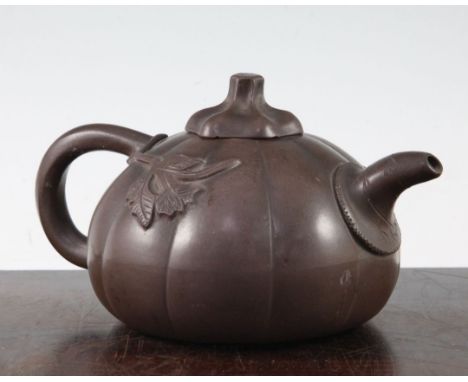 A Chinese Yixing melon-shaped teapot and cover, 19th / 20th century, modelled in relief with flowers, length 18cm