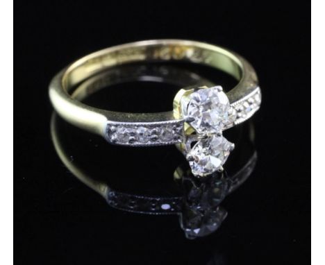 An 18ct gold and two stone diamond ring, with diamond set shoulders, size K.