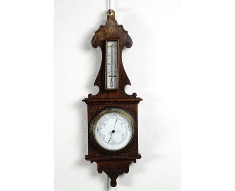 A carved oak aneroid barometer, 58 cm high