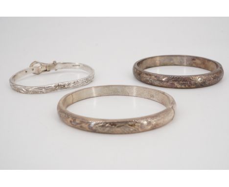 Two white metal hinged bangles, 25 g, together with a Mexican hinged "belt" bangle