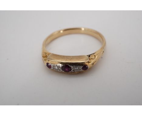 A vintage ruby and diamond ring, its navette face set with three rubies divided by small diamonds millegrain-set on a preciou