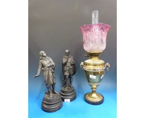 A brass urn shaped oil lamp together with a pair of figures