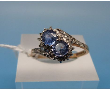 A 9ct gold ring set with two blue topaz surrounded by diamonds (size R)