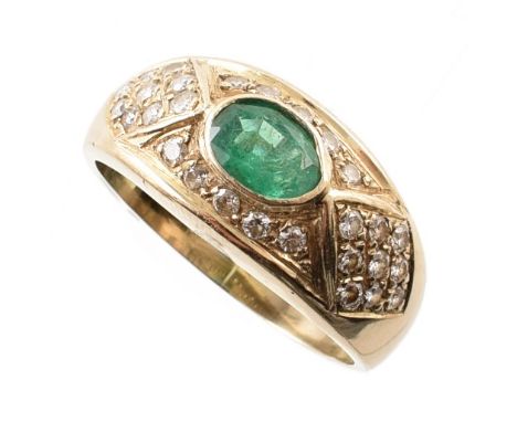 Emerald and diamond 18ct yellow gold ring , central mixed cut oval emerald measuring approx. 6mm x 5mm, bezel set with a surr