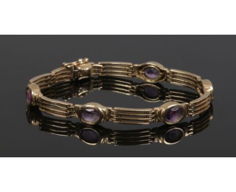 A 9ct gold pierced gate bracelet set with five ovoid amethyst, gross weight 13.6 grams.
