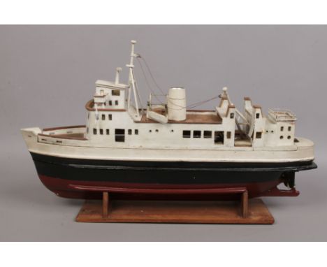 A scratch built model of a car ferry missing its motor.