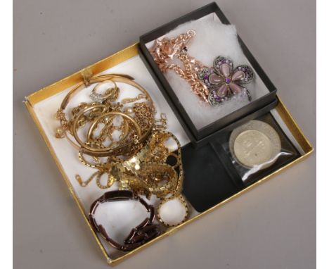 A quantity of yellow metal costume jewellery including necklaces, white paste set ring etc, along with a ladies fossil dress 