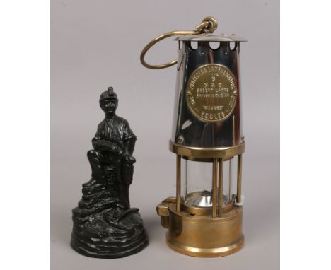 An Eccles type 6 miners re-lightable protector lamp along with a carved coal figure of a miner.