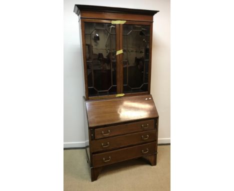 An Edwardian mahogany and barber pole banded bureau bookcase, the upper section with two glazed doors enclosing adjustable sh