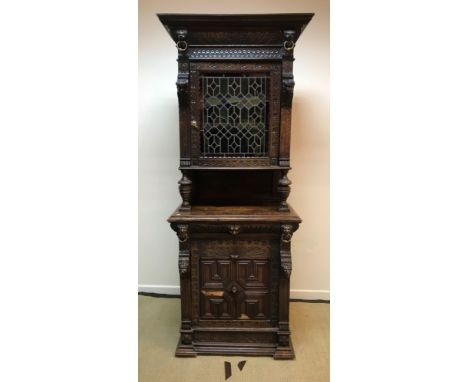 A Victorian carved oak Gothic Revival cabinet, the moulded and carved cornice with lion mask brass ring decoration over a col