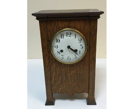 A circa 1900 oak cased mantel clock in the Art Nouveau style, the eight-day movement with circular enamelled dial and Arabic 