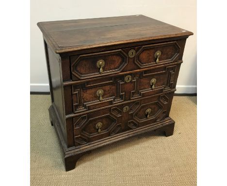 A 17th Century and later oak chest, the top with applied moulded edge over three long drawers with applied mouldings and bras