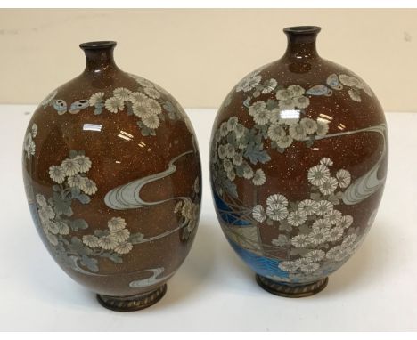 A pair of Chinese cloisonne egg shaped vases with narrow necks, the bodies decorated with butterflies amongst blossom with fe