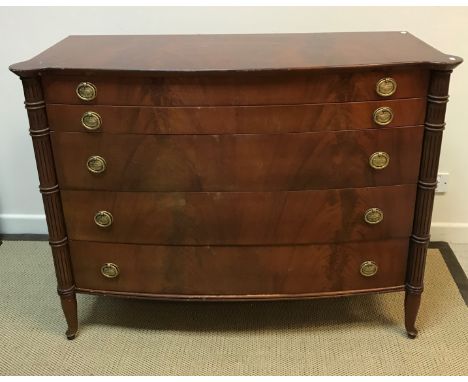 A 20th Century mahogany bow fronted chest in the Regency taste, the plain top over five long drawers with brass ring handles,