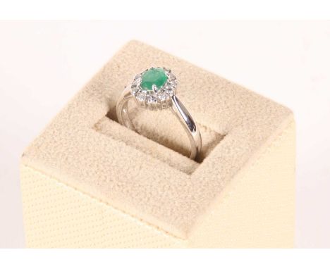 An 18 carat gold diamond and emerald set cluster ring, size M