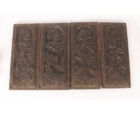 A set of four carved oak panels. probably 16th/17th century, each relief decorated with a profile portrait and foliage, 46 x 
