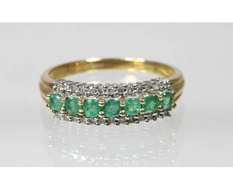 A 9 carat gold seven stone emerald dress ring, set in three rows, size P