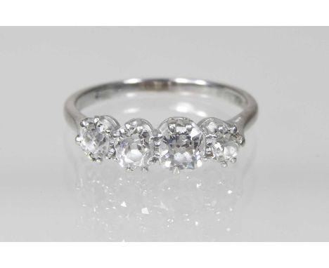 An 18 carat white gold and platinum set four stone diamond ring, of graduated design, approximately 1.2 carats gross, size N/