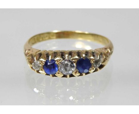 An 18 carat gold sapphire and diamond five stone ring, having a textured mount, size Q