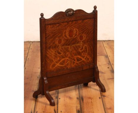 An Art Nouveau oak fire screen, early 20th century, having a stylised floral inlaid panel, 69 x 55cm
