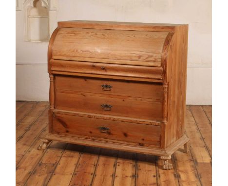 A large continental pine cylinder bureau, 19th century, the domed lid lifting to reveal an arrangement of drawers and pigeon 