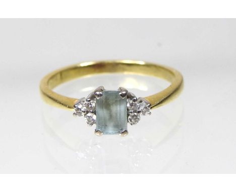 An 18 carat gold diamond and aquamarine ring, the central aquamarine flanked by six diamonds, size N