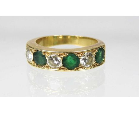 An 18 carat gold emerald and diamond half hoop eternity ring, approximately 1.0 carats and 1.0 carats, size L