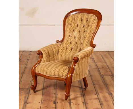 A Victorian mahogany armchair, having a scroll frame, button back and striped gold upholstery