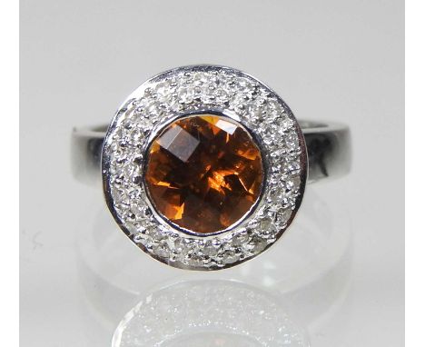 An 18 carat white gold yellow topaz and diamond halo ring, size N