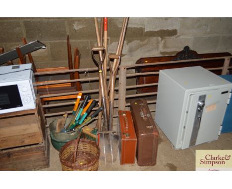 A quantity of long handled gardening tools; a quantity of hand tools; wicker baskets; two suitcases etc
