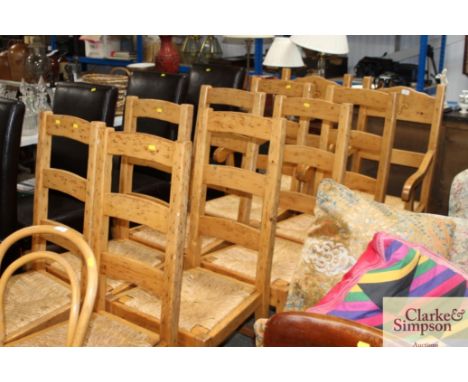 A set of ten modern pine and ladder back rush seated dining chairs; eight standards and two elbows