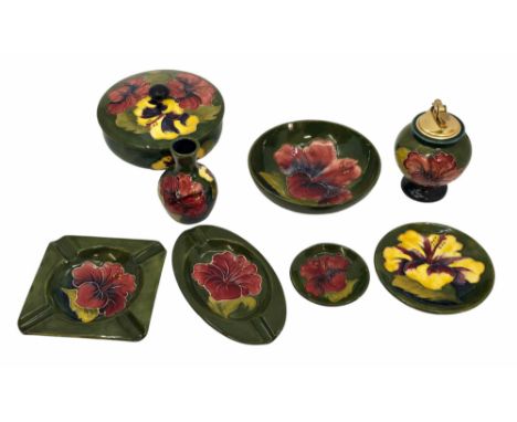 A collection of Moorcroft Hibiscus pattern pottery. (8) Vibrant tube lined red and yellow flowers on a green background. Impr