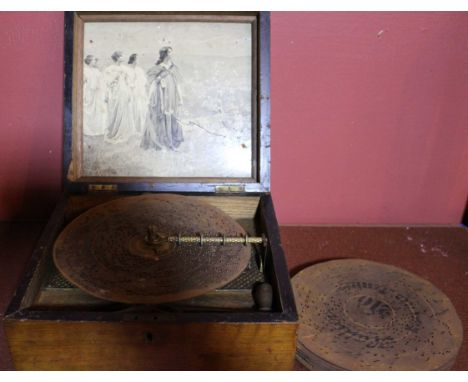 A Victorian Sonopol polyphon disc player with print to lid includes 10 discs and winding handle, this does wind and play but 