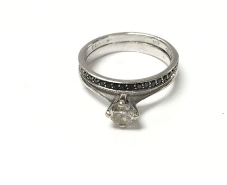 An 18ct white gold and diamond solitaire ring Approx 0.35ct with an attached 18ct black diamond half eternity ring. 3.33g and