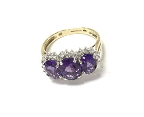 9ct yellow and white gold triple amethyst and diamond dress ring. Oval amethyst 2.50ct. RC diamonds 0.24ct. 3.35g and size N 