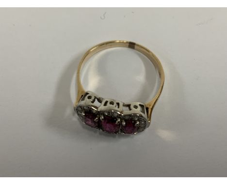 A 9ct gold pink sapphire and and diamond cluster ring. (A).