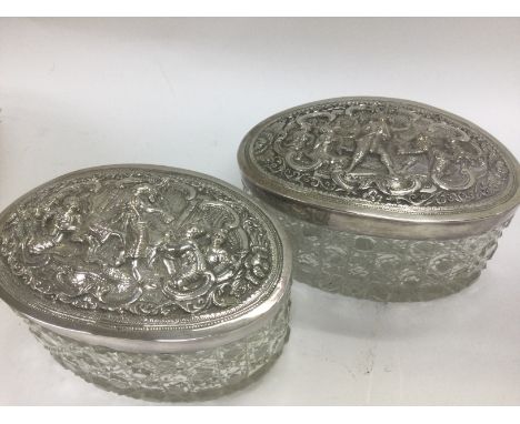 A pair of oval cut glass tidy jars the with Indian silver lids .