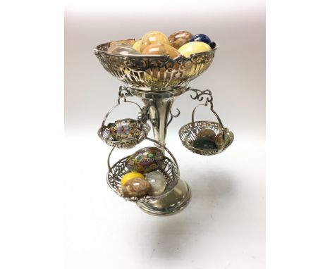 A silver plated epergne with hanging baskets inset with marble eggs.