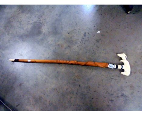 A walking stick with carved intertwined snake and goat shape handle.