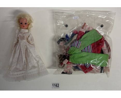 A Sindy doll in wedding dress and a quantity of vintage Sindy clothes.The doll is free from any teeth marks or chews, has all