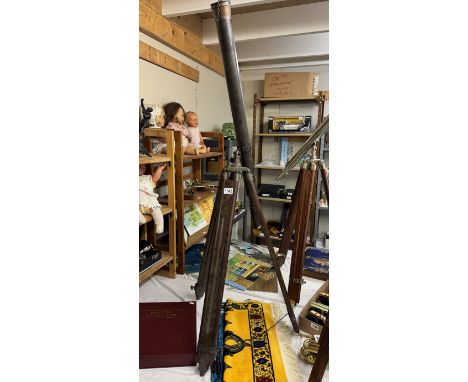 A large patinated brass telescope on teak tripod