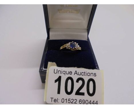 An un-marked yellow metal ring set central sapphire and diamonds, size K, 2.31 grams.