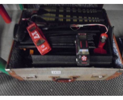 A suitcase of Scalextric including track, controllers and two Ford Sierra cars.