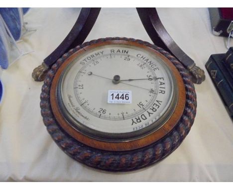 A large oak aneroid barometer with rope twist case.