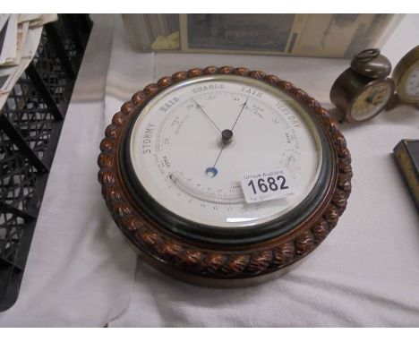 An aneroid barometer in oak rope twist case.