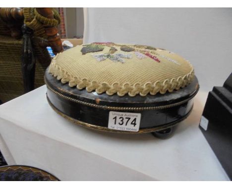 A Victorian footstool with tapestry top.