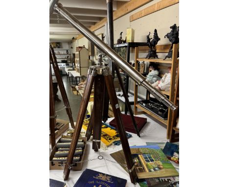 A large silver plated telescope on teak tripod