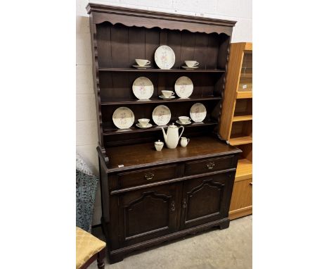 A dark oak dresserBase width 125cm, depth 50cm, height 89cm.Top width 121cm, height 107cm, shelf depth 14cm.