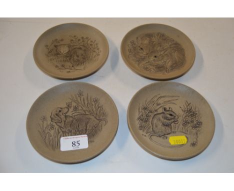 Four Poole pottery dishes, each decorated with animals 