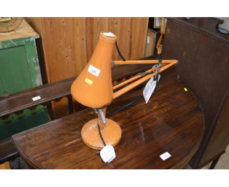 An orange angle poise lamp